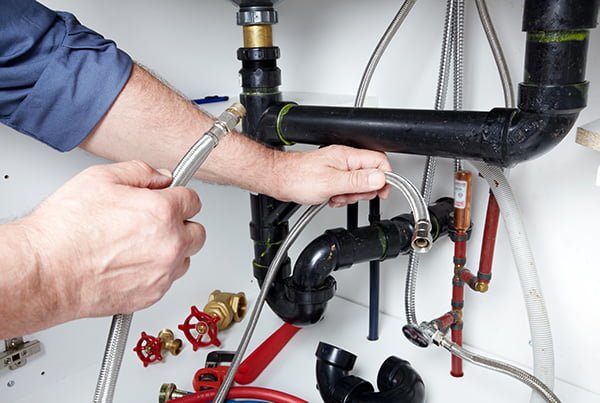 plumber fixing pipes with flex pipes